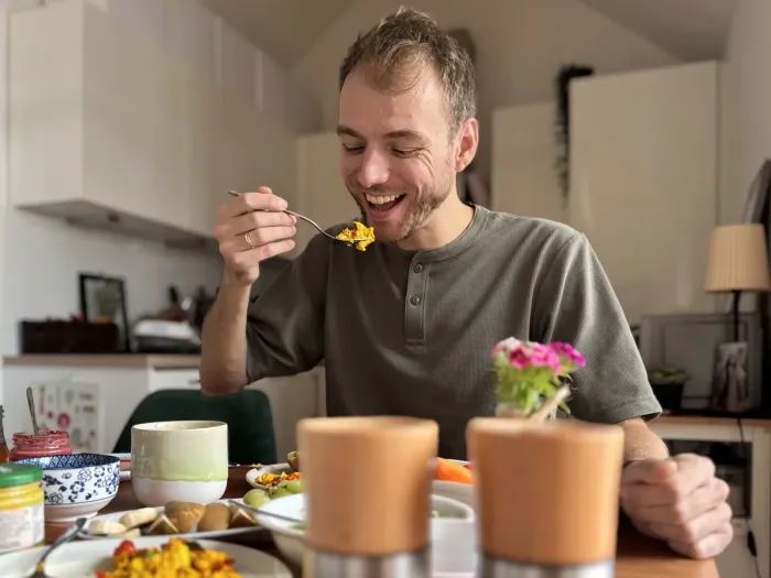 Marvin, der lachend einen Bissen Scrambled Tofu isst
