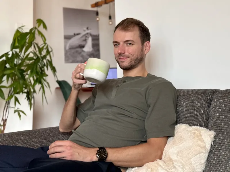 Marvin sitzt mit einer Tasse Tee auf der Couch und schaut aus dem Fenster