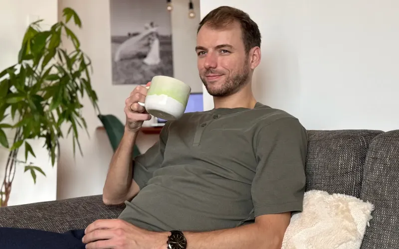 Marvin sitzt mit einer Tasse Tee auf der Couch und schaut aus dem Fenster