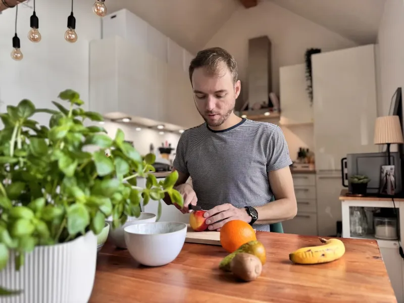 Marvin, der an einem Tisch sitzend Obst schneidet