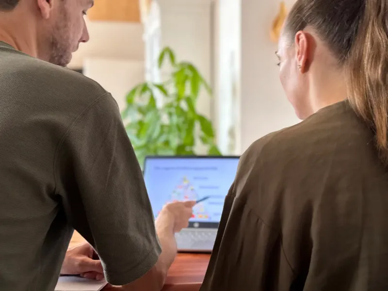Marvin zeigt in einer Beratung auf einen Laptop